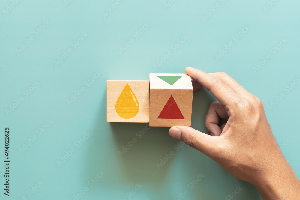 Wooden cube change UP arrow and Down arrow and oil symbol on green background. Oil with arrow up Wooden cube change UP arrow and Down arrow and oil symbol on green background. Oil with arrow up