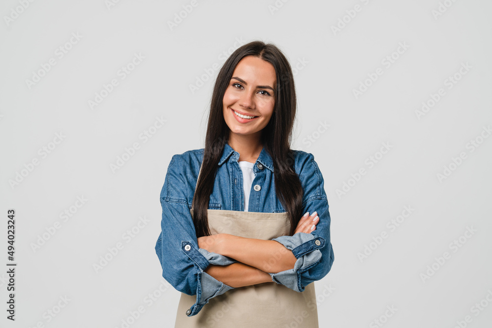 Young smiling caucasian female barista bar tender coffee maker woman in apron selling coffee hot beverage tea with arms crossed isolated in white background. Young smiling caucasian female barista bar tender coffee maker woman in apron selling coffee hot beverage tea with arms crossed isolated in white background.
