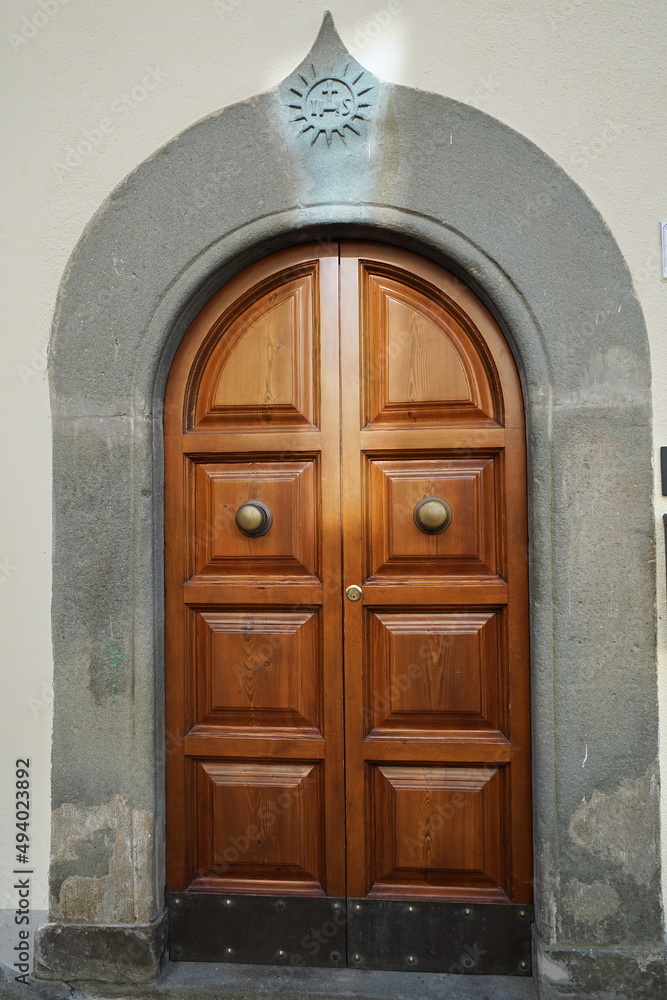 Old door with coat of arms in the village of Molazzana in Garfagnana, Tuscany, Italy