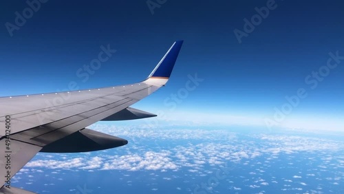 Wing of airplane flying above the clouds.