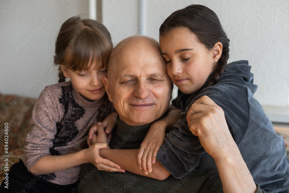 Fototapeta premium Ukrainian grandfather and two granddaughters hugging