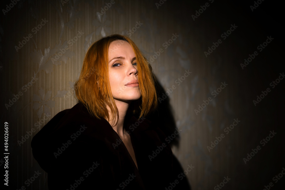 Middle aged woman dramatic portrait. A woman of forty years old, illuminated by a beam of light. Meditation, midlife crisis concept. Middle aged woman dramatic portrait. A woman of forty years old, illuminated by a beam of light. Meditation, midlife crisis concept.