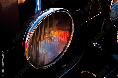 Closeup of the shiny headlight of an old car photo