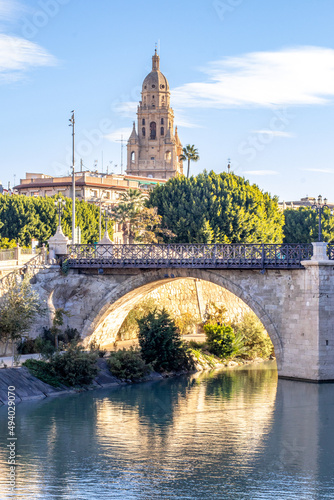 Vertical shot of a historic bridge and cathedral tower in Murcia, Spain photo
