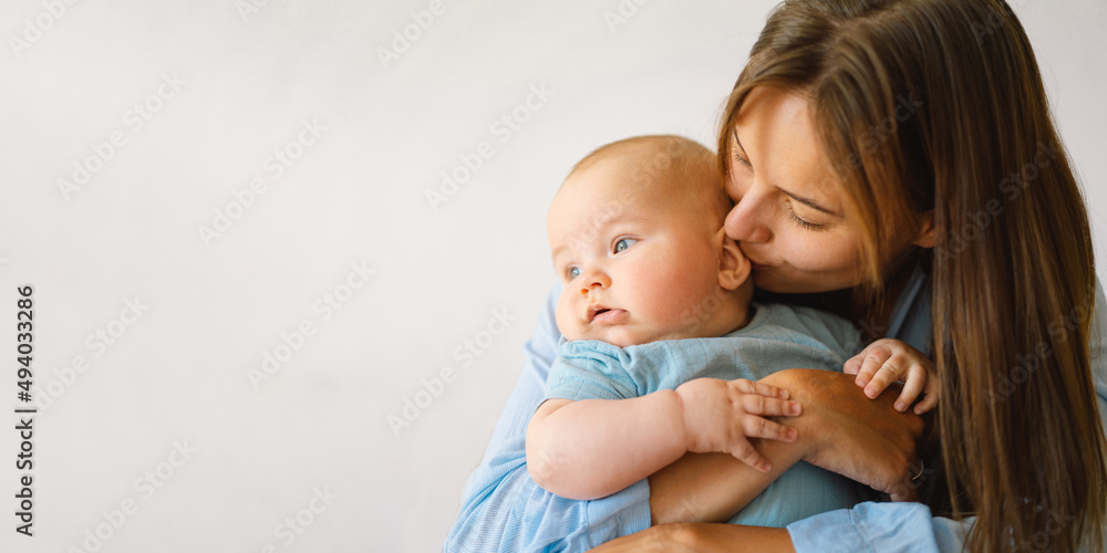A young mother is play with little baby boy. Mother of a nursing baby. Happy motherhood. The family is at home. Portrait of a happy mother and child. A young mother is play with little baby boy. Mother of a nursing baby. Happy motherhood. The family is at home. Portrait of a happy mother and child.
