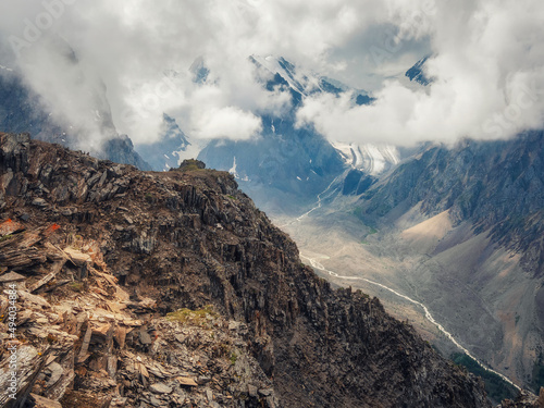 Amazing spring landscape with silhouettes of big rocky mountains and epic deep gorge with river.The edge of a rocky cliff with a beautiful view of the gorge.