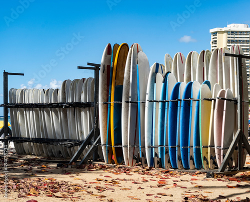 Multicolored surfboards standing on a board rack on a Hawaiian beach