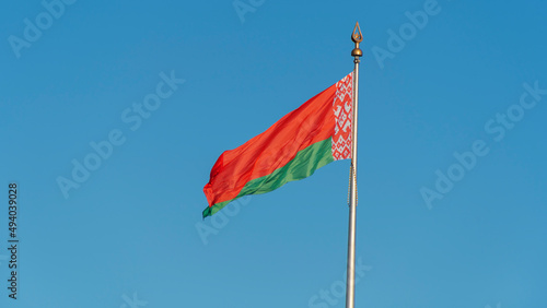 State flags of the Republic of Belarus are waving in the wind on blue sky background. Space for text.