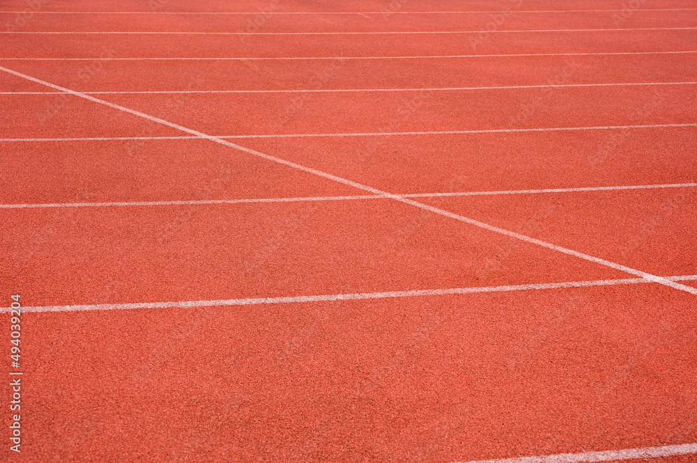 Side view of running track with white line racetrack outdoor stadium. red texture.