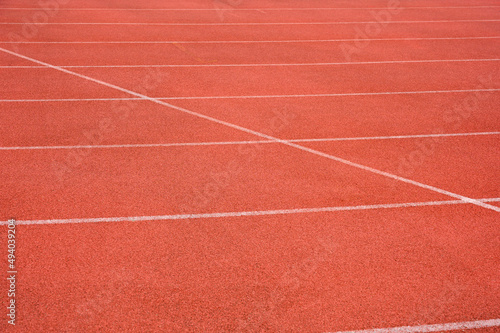 Side view of running track with white line racetrack outdoor stadium. red texture. © bigy9950