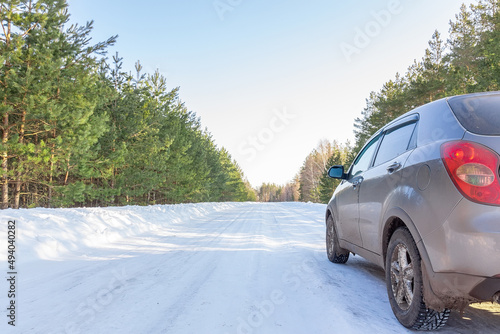Car on winter snow road in coniferous forest