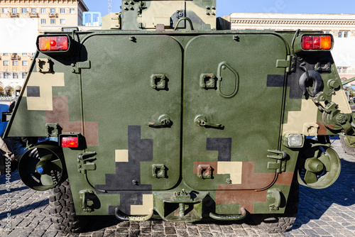 Texture of armored personnel carrier for transportation of troops. Fragment of military armored vehicles. Green khaki camouflage. Back view