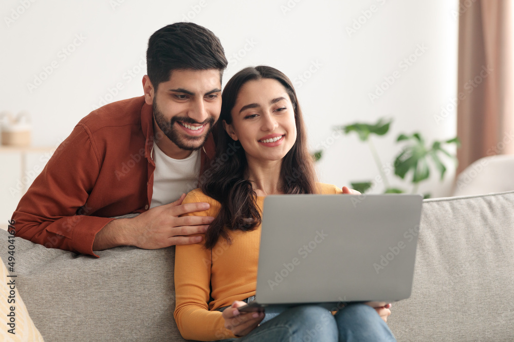 Arabic Spouses Using Laptop Computer Browsing Internet Sitting At Home Arabic Spouses Using Laptop Computer Browsing Internet Sitting At Home