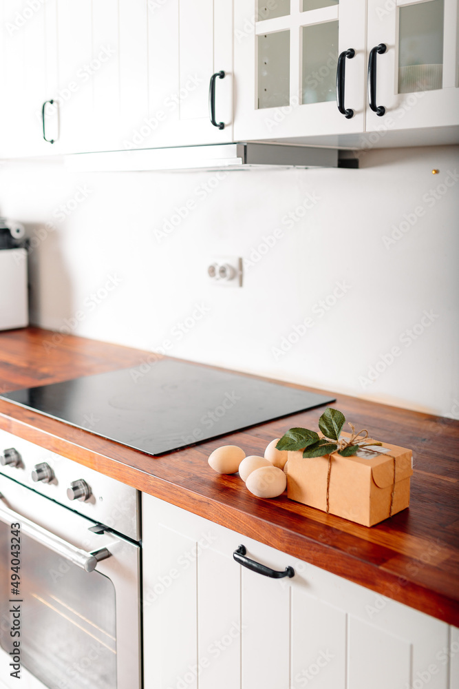 White kitchen with eggs and gift box. Happy easter card with wooden eggs. White kitchen with eggs and gift box. Happy easter card with wooden eggs.