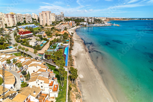 Aerial shot Dehesa de Campoamor townscape with sandy beach. Spain