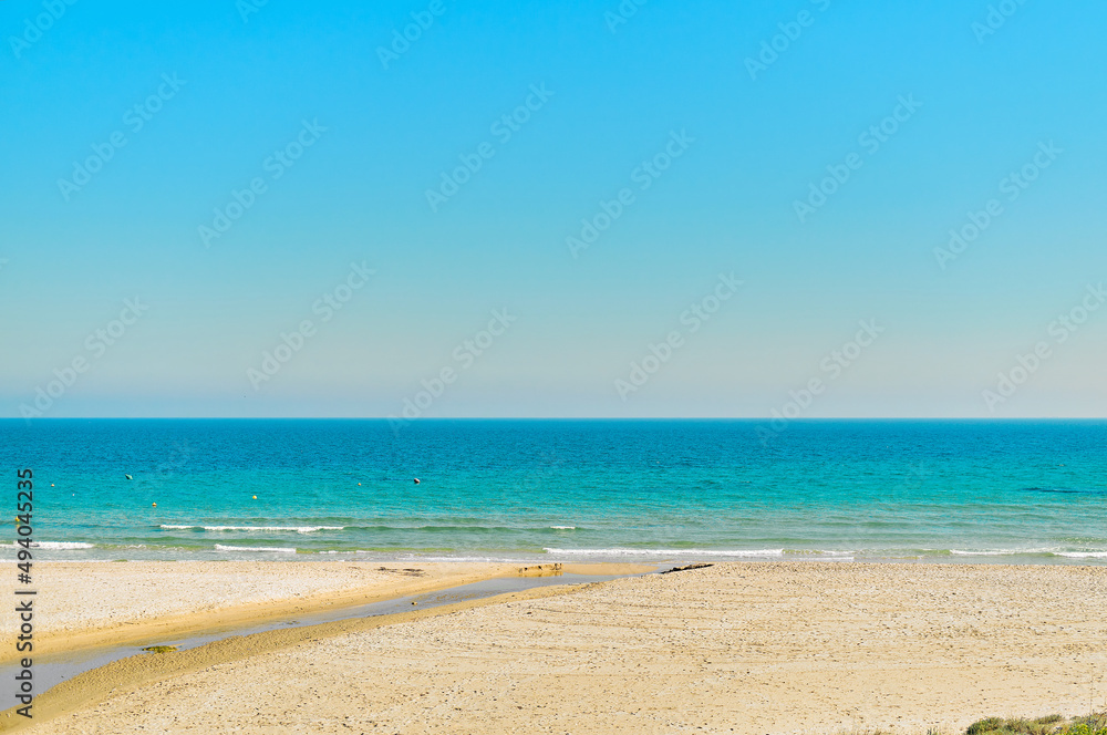 Empty sandy beach and turquoise waters of Mediterranean Sea. Spain
