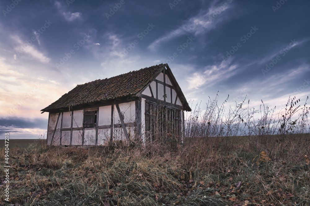 Ταπετσαρία old little half-timbered barn in the field with moving clouds in the background
