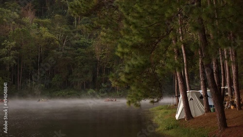 Camping tents in a camping in a forest by the mist river. Travel lifestyle. Adventure and tourism in Thailand. Outside resting on nature.  photo