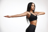 Your body gets better with movement. Studio shot of a sporty young woman stretching her arms against a white background.