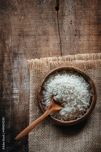 Foto bol de arroz sobre una tela de arpillera sobre una vieja mesa de madera, con esp