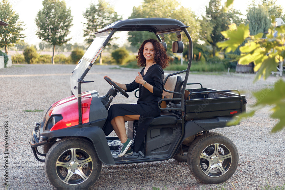 Cheerful young woman showing thumb up, poses in vehicle outside. Cheerful young woman showing thumb up, poses in vehicle outside.