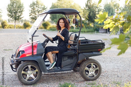 Cheerful young woman showing thumb up, poses in vehicle outside.