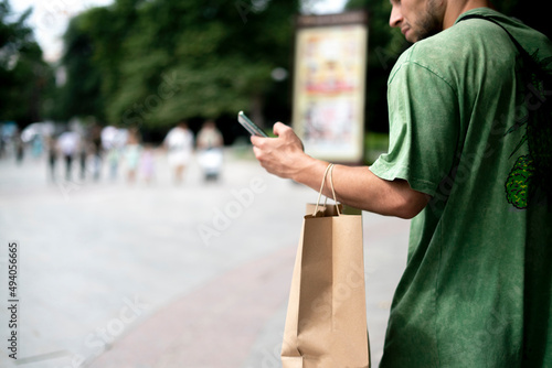 young male person move in the city with a paper bag, products delivery