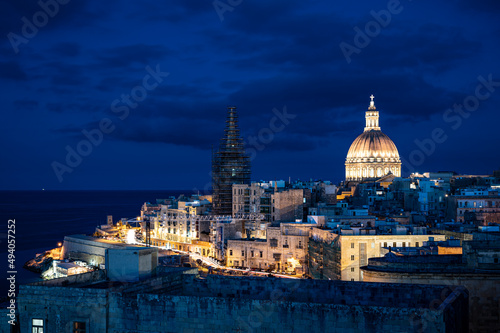 Panoramic view of illuminated at night Valletta old town and harbor in Valletta, Malta.