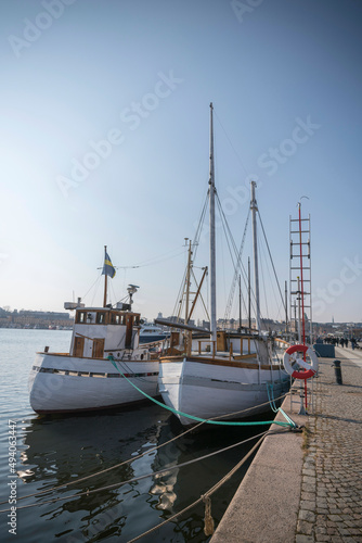 Old fishing boats at a pier in the bay Nybroviken a sunny spring day in Stockholm