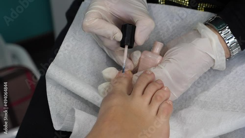 Piedi di una giovane donna che fa pedicure. Terapia del piede in una spa, Smalto sulle unghie, pulizia e taglio. photo