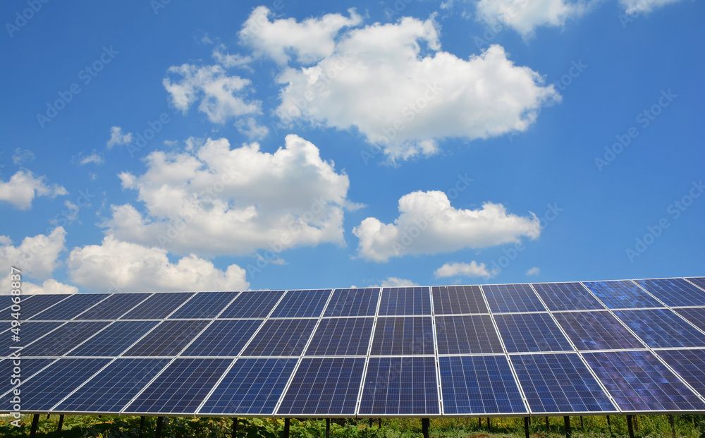 Solar panel background. A large ground mounted solar panel against the blue sky as a source of renewable sustainable green energy. Solar panel background. A large ground mounted solar panel against the blue sky as a source of renewable sustainable green energy.