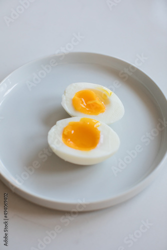 7 minute hard boiled egg cut open on a small white plate on white countertop