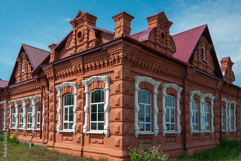 Fototapeta premium An old red brick building with white windows.