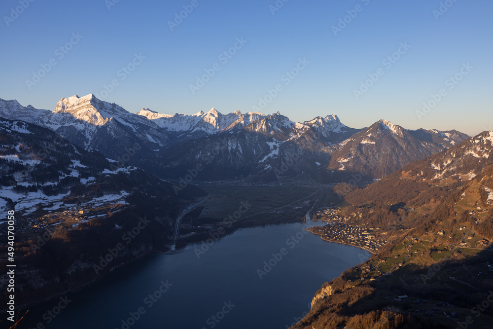 Great view on a beautiful morning over a lake called Walensee. The mountains in the background are illuminated by the morning sun.