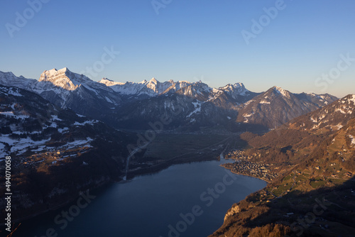 Great view on a beautiful morning over a lake called Walensee. The mountains in the background are illuminated by the morning sun. © Philip