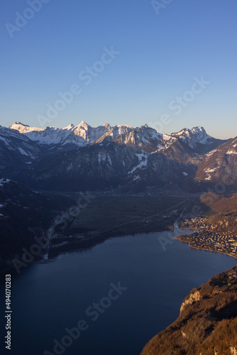 Great view on a beautiful morning over a lake called Walensee. The mountains in the background are illuminated by the morning sun. © Philip