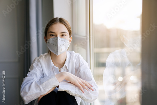 COVID-19 Pandemic Coronavirus. Young girl home isolation quarantine wearing face mask ffp2 protective for spreading of virus SARS-CoV-2 photo
