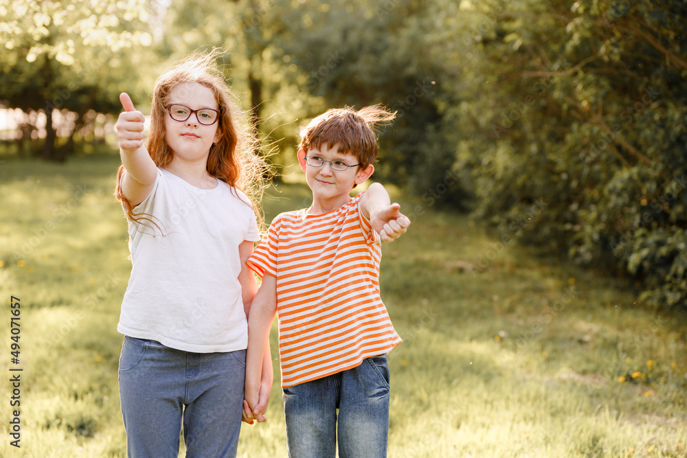 Fototapeta premium Child in glasses show thumbs up outdoor.