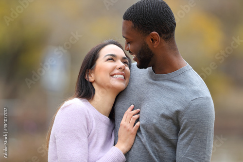 Happy interracial couple in love looking each other photo