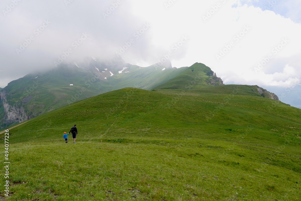 Father and son hiking in Flumser Kleinberg region. St. Gallen, Switzerland. Father and son hiking in Flumser Kleinberg region. St. Gallen, Switzerland.