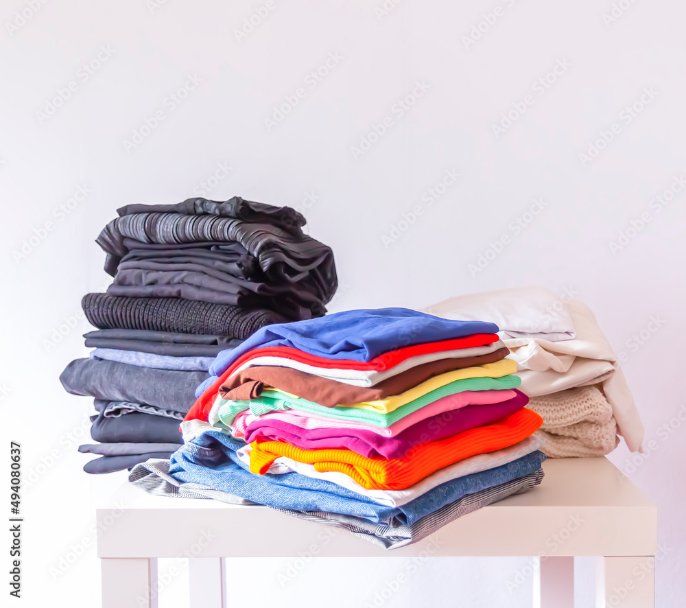 Stack of folded colorful clothes on white background. Stack of folded colorful clothes on white background.