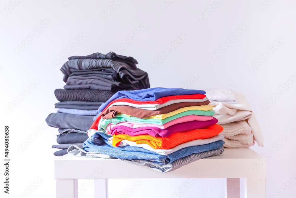 Stack of folded colorful clothes on white background. Stack of folded colorful clothes on white background.