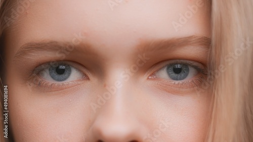 Extreme close-up shot of young blonde woman looks at the camera