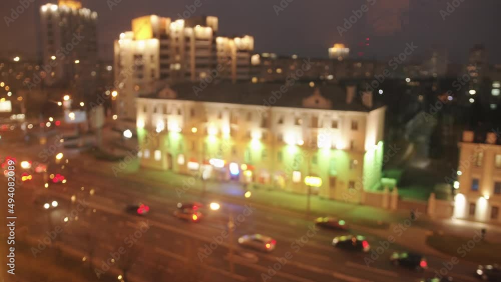 Blurred lights of the evening city and busy traffic along the avenue from the window on the top floor of the building. Bokeh effect Blurred lights of the evening city and busy traffic along the avenue from the window on the top floor of the building. Bokeh effect