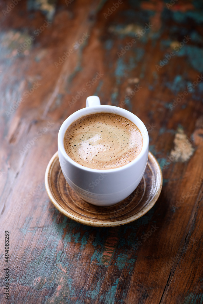 Fototapeta premium Cup of coffee on rustic wooden background. 