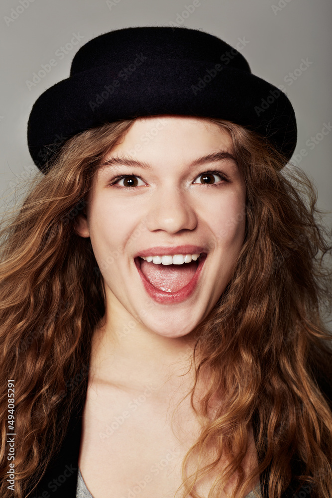 Shes happy and stylish. Closeup portrait of a trendy young teenage girl standing against a gray background. Shes happy and stylish. Closeup portrait of a trendy young teenage girl standing against a gray background.