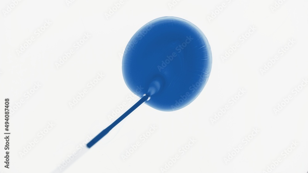 Top view macro shot of chemical dropper injects blue liquid into transparent one on white background | Abstract cosmetics formulating concept Top view macro shot of chemical dropper injects blue liquid into transparent one on white background | Abstract cosmetics formulating concept