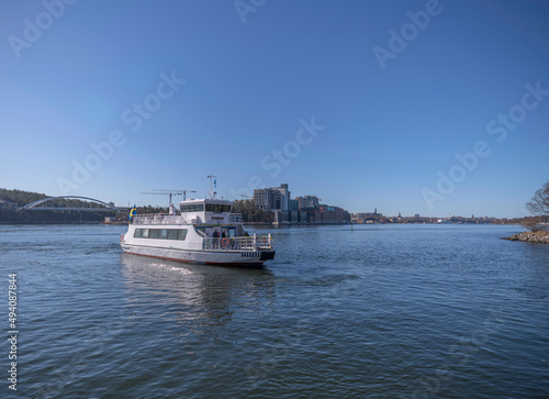 Commuting boat leaving a jetty with apartment houses as skyline a sunny spring day in Stockholm © Hans Baath