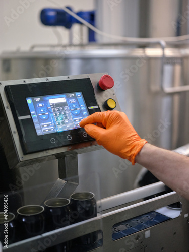 Man working with an electronic beer filling machine in a brewery