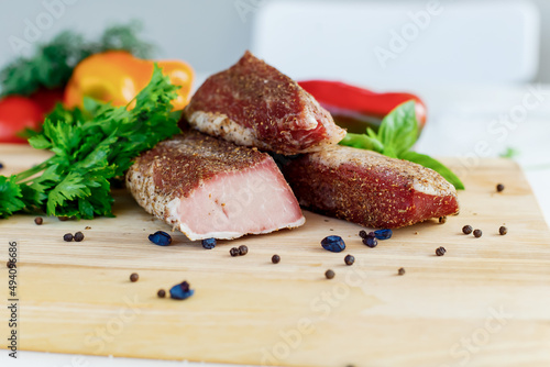 meat on a wooden board with vegetables
